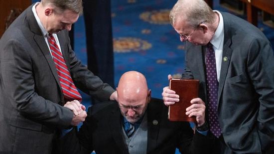 Louisiana Republican Clay Higgins, flanked by Mississippi Republicans Michael Guest, left, and Mike Ezell, holds a Bible on T